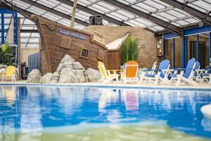 a swimming pool with a pool table and chairs at Marine Holiday Park in Rhyl