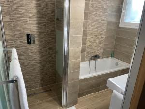 ein Badezimmer mit einer Dusche, einer Badewanne und einem Waschbecken in der Unterkunft Villa Hotel in Saint-André-les-Vergers