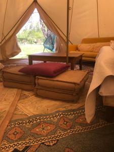 Habitación con tienda de campaña con almohadas y mesa en Domaine de la Gaucherie en Langon
