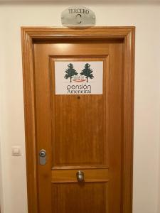 a wooden door with a sign on top of it at Pension Ameneiral in O Pedrouzo