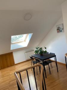 a dining room with a black table and chairs at Pension Ameneiral in O Pedrouzo