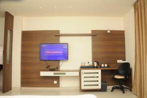 a room with a desk and a tv on a wall at Madhuvan Suites By Blues in Dwarka