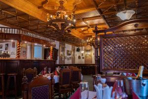 a dining room with tables and chairs and a chandelier at Hotel Praha in Boží Dar