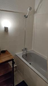 a bathroom with a bath tub with a shower at Bordeaux : grand studio cosy avec cour privative in Bordeaux