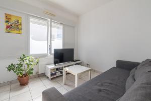 - un salon avec un canapé et une télévision dans l'établissement LES CELTES - Appartement pour 6, à Saint-Nazaire