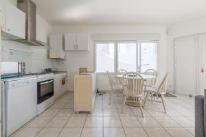 une cuisine avec une table et des chaises. dans l'établissement LES CELTES - Appartement pour 6, à Saint-Nazaire