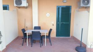 a table and chairs in front of a building with a door at Bilocale RESIDENCE MARASUSA in Parghelia