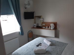 a bedroom with a bed with two towels on it at Manchester House in Blackpool