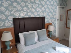ブラックプールにあるManchester Houseのベッドルーム1室(青と白の壁紙のベッド1台付)