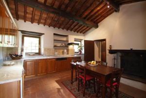 una grande cucina con tavolo e sedie in legno di Agriturismo Vinci a Gaiole in Chianti