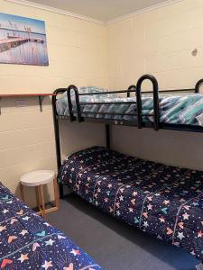 a room with two bunk beds and a table at Peter's Port in Pine Point