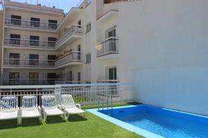 ein Gebäude mit einem Pool neben einem Gebäude in der Unterkunft Hotel Armonía in Lloret de Mar