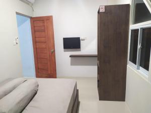 Schlafzimmer mit einem Bett und einer Holztür in der Unterkunft Rooms at Josapa Guest House in Batam Center