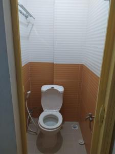 a small bathroom with a toilet in a stall at Rooms at Josapa Guest House in Batam Center
