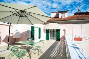 a patio with a table and chairs and an umbrella at A~Mare Casa Vacanze in Fezzano