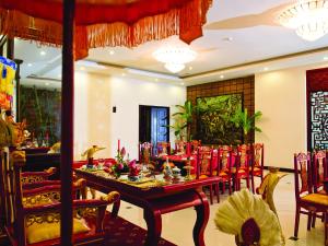 a dining room with red chairs and a table at Cherish Hue Hotel in Hue
