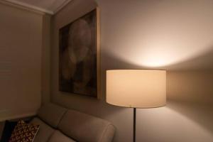 a lamp in a room with a couch and a painting at Urzaiz Centro Vigo in Vigo