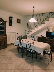 a dining room with a table and chairs and a staircase at Casa Andrea in Cadarese