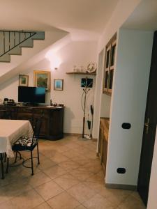 Cadarese的住宿－Casa Andrea，一间带桌子和书桌的客厅以及楼梯。