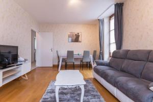 a living room with a couch and a table at Le Papillon in Cosne-Cours-sur-Loire