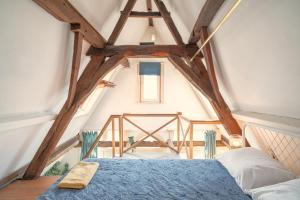 - une chambre mansardée avec un lit bleu dans l'établissement The Charming Hendrik Square Apartments, à Anvers