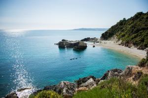 a beach with a group of people swimming in the water at Xigia Escape villas in Khartáta