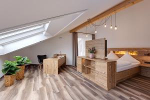 ein Büro im Dachgeschoss mit einem Bett und einem Schreibtisch in der Unterkunft Edelfinger Hof in Bad Mergentheim