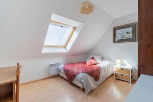 ein kleines Schlafzimmer mit einem Bett und einem Fenster in der Unterkunft Ty Yann in Carantec