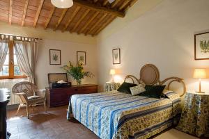 a bedroom with a bed and a table and chairs at Fattoria di Rignana in Greve in Chianti