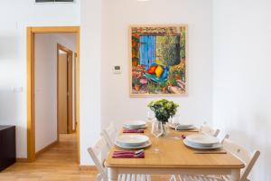 een eettafel met stoelen en een schilderij aan de muur bij Medinaceli airco, wifi and free parking in Valencia +26 foto's