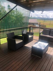 a deck with chairs and a coffee table on it at Le Bella Dons in Graskop