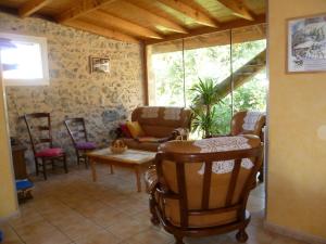 a living room with rocking chairs and a table at La grange des chouettes in Ilheu