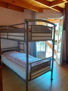 two bunk beds in a room with a window at La grange des chouettes in Ilheu