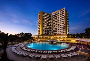 a hotel with a swimming pool in front of a building at Pestana Delfim All Inclusive Hotel in Alvor