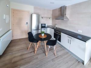 a kitchen with a table and chairs and a refrigerator at DOMVS I in El Burgo de Osma