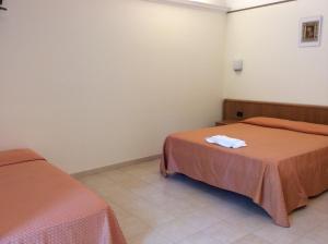 a room with two beds with orange sheets at Hotel Il Saraceno in Volastra