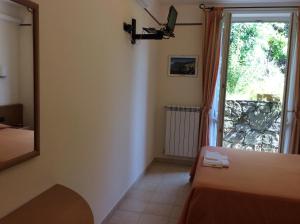 a room with a bed and a mirror and a window at Hotel Il Saraceno in Volastra