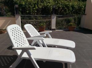 three white chairs sitting next to each other on a patio at Hotel Il Saraceno in Volastra