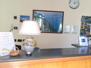 a lamp sitting on top of a counter with a clock at Hotel Il Saraceno in Volastra