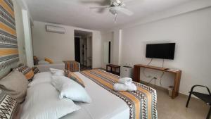 1 dormitorio con 2 camas y TV de pantalla plana en Montelaguna Boutique Hotel, en Sámara