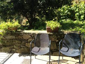 two chairs sitting in front of a stone wall at Hotel Il Saraceno in Volastra