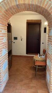 a room with a brick wall and a table and a door at Lucignolo in Lucignano