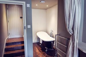 a small bathroom with a white sink and stairs at The Nest Hotel & Restaurant in Petersfield