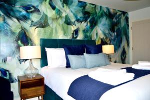 a bedroom with a bed with a blue and green wallpaper at The Nest Hotel & Restaurant in Petersfield