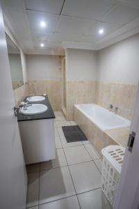 uma casa de banho com uma banheira e um lavatório e uma banheira em Stay at The Point - Triumphant Tropical Tranquility em Durban
