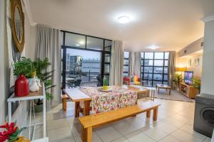 uma sala de estar com uma mesa e um sofá em Stay at The Point - Triumphant Tropical Tranquility em Durban