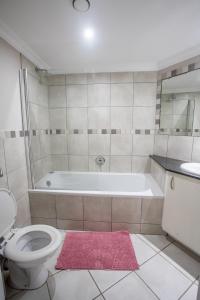 uma casa de banho com uma banheira, um WC e um lavatório. em Stay at The Point - Triumphant Tropical Tranquility em Durban