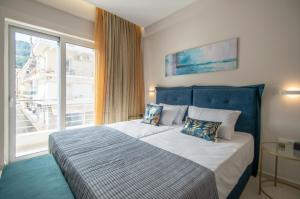 a bedroom with a large bed with a large window at Alcmene Lux Apartment in Zakynthos Town