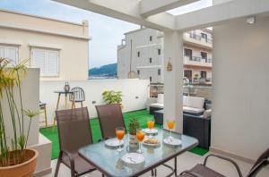 a patio with a table and chairs on a balcony at Alcmene Lux Apartment in Zakynthos Town
