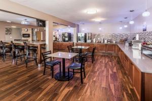 a restaurant with tables and chairs and a kitchen at Super 8 by Wyndham Iowa City/Coralville in Coralville